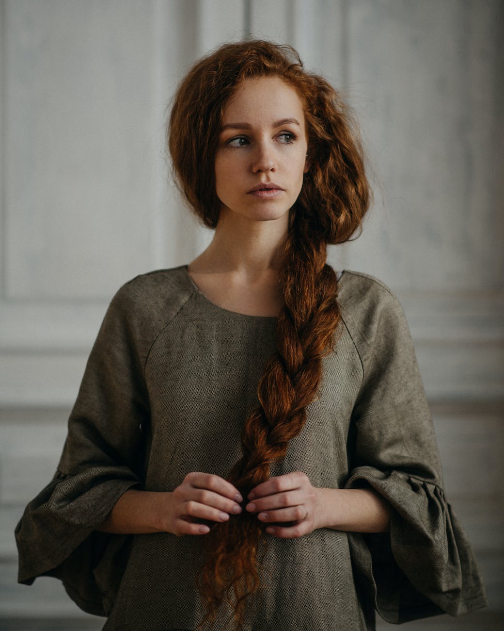 woman touching thick red braid